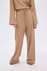 Pantalón de calce ancho y tiro alto, color beige con textura.