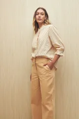 Pantalón de vestir color beige, de corte wide leg y tiro alto, con bolsillos laterales y traseros.