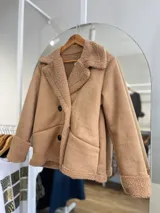 Chaqueta marrón con forro tipo corderito, doble botonadura y cuello con solapas.