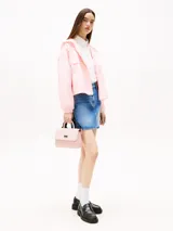 Cartera Tommy Jeans color rosa con asa superior, correa ajustable negra, cierre de solapa magnético, dos compartimentos principales y bolsillo interior con cremallera.