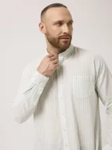 Camisa de manga larga a rayas verticales azules y blancas, con cuello abotonado y bolsillo en el pecho. Confeccionada en lino y algodón.