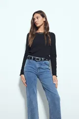 Jean de denim negro de corte recto, con aplicaciones de strass en las piernas.