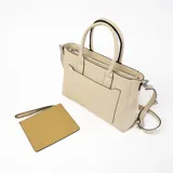 Cartera tipo tote de cuero sintético color beige con bolsillo frontal y correa bandolera ajustable y desmontable.