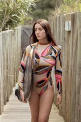 Enteriza de surf de mangas largas con espalda abierta y estampado de hojas en tonos beige, marrón, rosa, naranja y celeste.