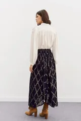 Falda larga de viscosa jacquard con lurex dorado, estampado geométrico, tajo central, ruedo irregular y cintura elastizada.