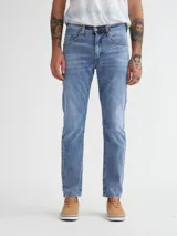 Jean color azul claro, de corte slim, con detalles de costura y cinco bolsillos.