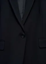 Blazer negro de corte entallado, con solapas de muesca, cierre de un botón, dos bolsillos de solapa y puños abotonados.