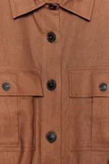 Camisa color marrón con cuello solapa y manga larga acabada en vuelta con trabilla y botón. Bolsillos delanteros de plastrón con solapa. Bajo con aberturas laterales. Cierre frontal con botones y cinturón de la misma tela.