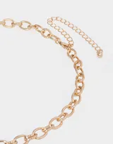 Collar corto dorado con cadena de eslabones gruesos y dije de frutilla rosa con detalles dorados.