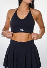 Conjunto deportivo negro compuesto por top con breteles finos y falda corta con volados.