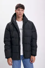 Campera negra capitonada con capucha y cierre frontal.