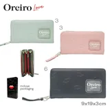 Billetera rectangular color verde agua con cierre perimetral y correa de mano. Diseño con textura de labios en relieve y logo de la marca en aplique transparente.