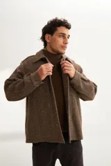 Camisa estilo leñadora marrón con diseño de espiga, cuello clásico, abrochadura frontal a la vista, bolsillos plaqué con tapa en el pecho, mangas largas con puño y botón.