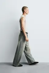 Pantalón de jeans de algodón, corte baggy fit, tiro medio, con efecto lavado en tonos grises y verdes. Presenta cinco bolsillos y cierre frontal con cremallera y botón.