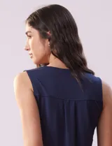 Blusa sin mangas en seda fría color blanco, marca Absolutely Famous. Escote en V con lazo entrelazado.