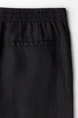 Pantalón negro de lino con corte recto, cintura elastizada con cordón ajustable, bolsillos laterales y bolsillo trasero.