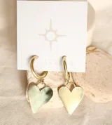 Aros tipo argolla gruesa de metal dorado, con dije colgante de corazón plano y texturizado.