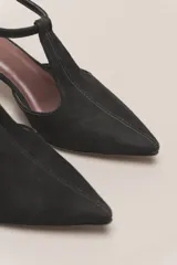 Sandalia de cuero color bordó, con acabado charolado, punta fina y tacón cuadrado de 5 cm. Presenta una tira en forma de T sobre el empeine y una correa con hebilla alrededor del tobillo.