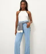 Pantalón de jeans de tiro alto, corte recto y color azul oscuro. Presenta costuras verticales contrastantes visibles en el frente de ambas piernas.