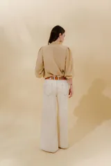 Pantalón de jean azul con corte sastrero de tiro medio bajo confeccionado en 100% algodón. Presenta cortes en los costados, dos bolsillos delanteros y dos traseros.