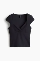 Top corto negro de punto interlock, ajustado al cuerpo, con escote corazón pronunciado y mangas japonesas. Presenta costuras moldeadoras frontales.