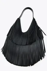 Bolso de hombro negro con flecos en el cuerpo, asa de hombro, bolsillo interior con cremallera y cierre mediante imán.
