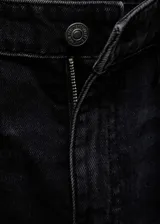Pantalón de jean negro de corte wide leg, tiro bajo y cinco bolsillos.