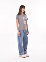 Remera negra de algodón con estampado frontal de la palabra "MERCI" en letras delineadas con colores del arcoíris.