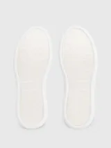 Zapatillas urbanas Calvin Klein blancas de cuero, con detalle en cuero negro en el talón y logo de la marca en el lateral.