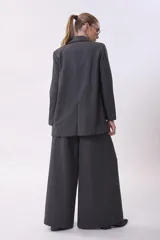 Blazer gris de lana con solapas de muesca, cierre cruzado con doble botonadura, bolsillos con solapa y corte holgado.