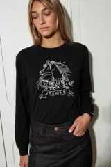 Remera negra de manga larga confeccionada en algodón, con cuello redondo y estampado de un caballo con rosas y la palabra "VDAMIANI" en color blanco.