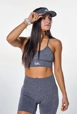 Conjunto deportivo gris jaspeado compuesto por top con breteles finos y logo 'bk.' estampado en el frente, y short de calce ajustado.