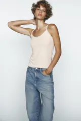 Pantalón de jean celeste de corte amplio, con tiro medio, cinco bolsillos y costuras torcidas.