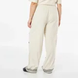Pantalón ancho color beige con bordado de cruces negras.