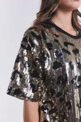 Vestido corto tipo remera de lentejuelas doradas y plateadas con estampado animal print negro y cuello redondo.