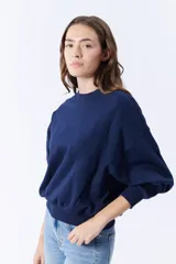 Buzo azul marino de corte holgado con mangas abullonadas y cuello redondo.