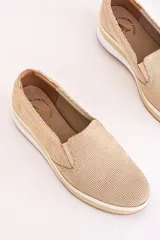 Slip-on deportivos color beige con textura cuadriculada, suela blanca con detalle en color crema y plantilla con logo estampado.