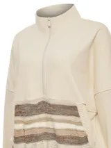 Buzo color beige con cierre frontal parcial y cuello alto. Presenta un bolsillo tipo canguro con diseño tejido a rayas horizontales en tonos marrón, beige y blanco.