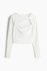 Top cropped blanco de punto elástico, con escote asimétrico y detalle girado en el frente, cut-out en el pecho, mangas largas y bajo recto.