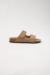 Sandalias planas color beige con dos tiras con velcro ajustables sobre el empeine y plantilla de corcho.