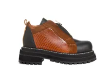 Botines de cuero negro con paneles laterales de charol, cierre frontal con cremallera y suela track.