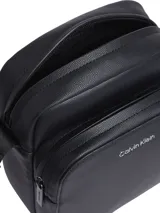 Bandolera negra Calvin Klein con correa ajustable con logo, cierre de cremallera y logo característico en la parte delantera.