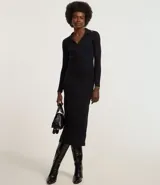 Vestido midi de punto negro con cuello polo, escote en V y manga larga.