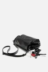 Bandolera negra con solapa y cierre magnético. Incluye llavero decorativo con forma de estrella. Tiene correa de hombro ajustable y extraíble. El interior cuenta con tres compartimentos, uno con bolsillo con cierre.