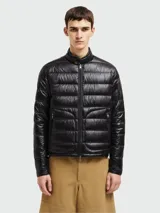 Campera puffer Moncler modelo Acorus, color verde oscuro, de corte entallado y largo a la cadera. Confeccionada en tejido técnico acolchado, cierre frontal con cremallera, cuello mao y bolsillos laterales con cremallera. Plegable y fácil de transportar.