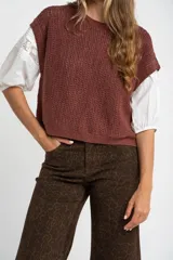 Chaleco de punto color beige con lurex, de corte recto y mangas cortas. Tejido calado con pequeños agujeros.