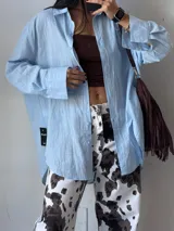 Camisa celeste de corte amplio y mangas largas.