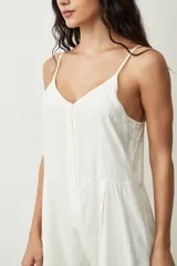 Mono corto color crudo, con breteles finos, escote en V y cierre frontal con botones.