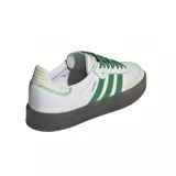 Zapatillas deportivas de cuero blanco con detalles en verde y suela negra.