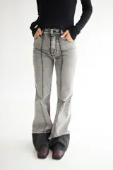 Pantalón de jean gris de corte acampanado, con tiro alto y costuras verticales al frente.